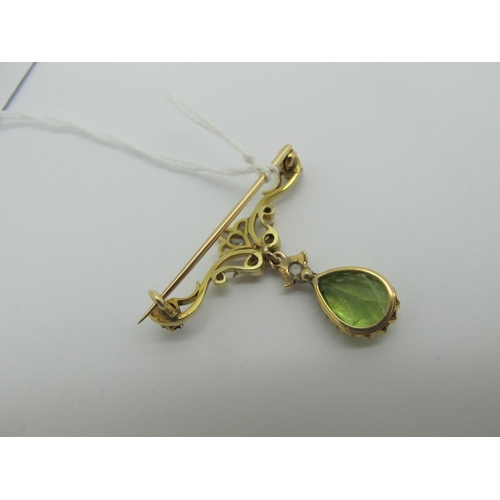 76 - An Edwardian Peridot and Diamond Set Pendant Brooch, teardrop claw set (stone crack) below scroll ba... 