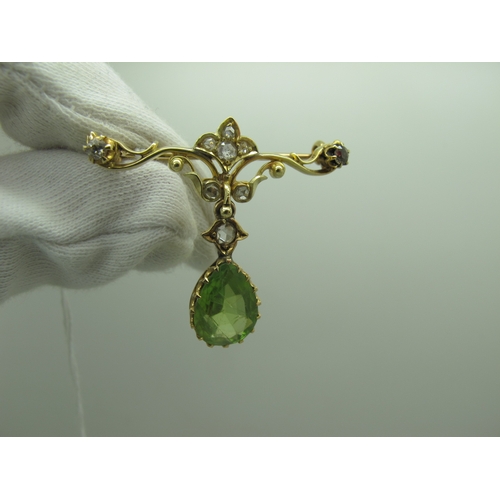 76 - An Edwardian Peridot and Diamond Set Pendant Brooch, teardrop claw set (stone crack) below scroll ba... 