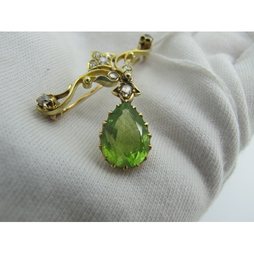 76 - An Edwardian Peridot and Diamond Set Pendant Brooch, teardrop claw set (stone crack) below scroll ba... 