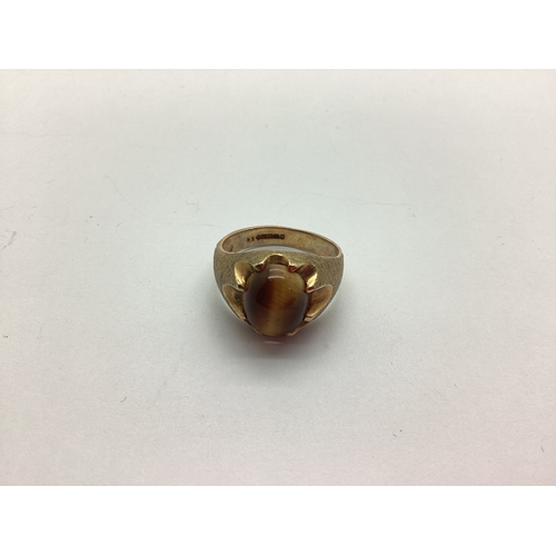 232 - A 9ct Gold Tiger's Eye Single Stone Ring, oval cabochon claw set between satin polished shoulders (f... 