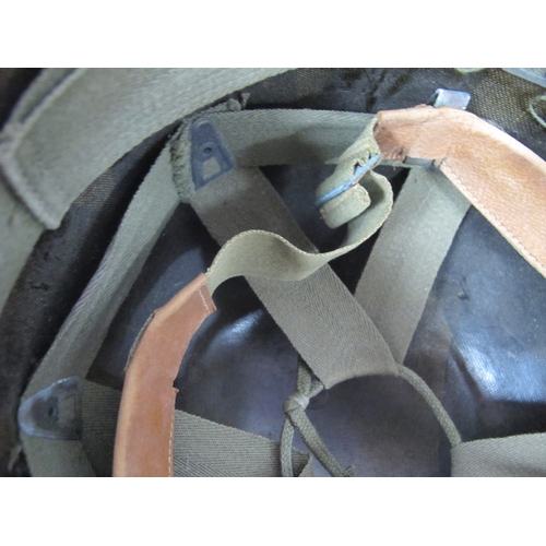 768 - United States M1 combat helmet liner with webbing cradle and leather chin strap.