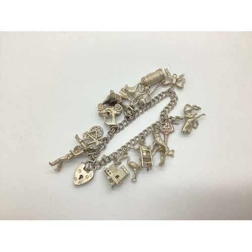 163 - A Double Curb Link Charm Bracelet, suspending numerous novelty charms, including 21 Key, Bullfighter... 