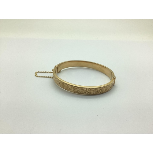 191 - A Chester Hallmarked 9ct Gold Hinged Bangle, leaf scroll engraved to the front (overall weight 9.5gr... 