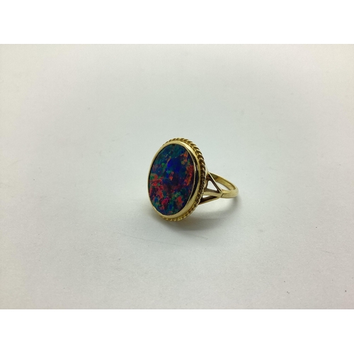 223 - An 18ct Gold Black Opal Doublet Single Stone Panel Ring, oval collet set, within ropetwist setting, ... 