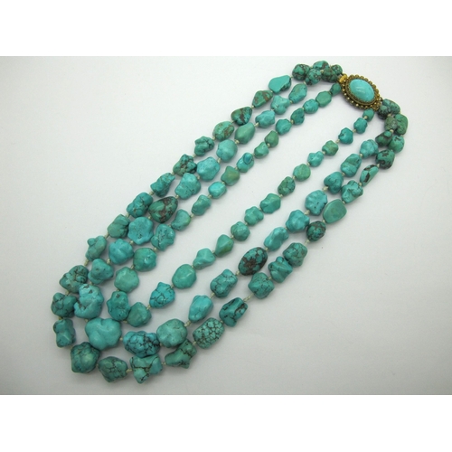 150 - A Three Row Graduated Turquoise Bead Necklace, the irregular beads knotted to gilt oval panel clasp,... 