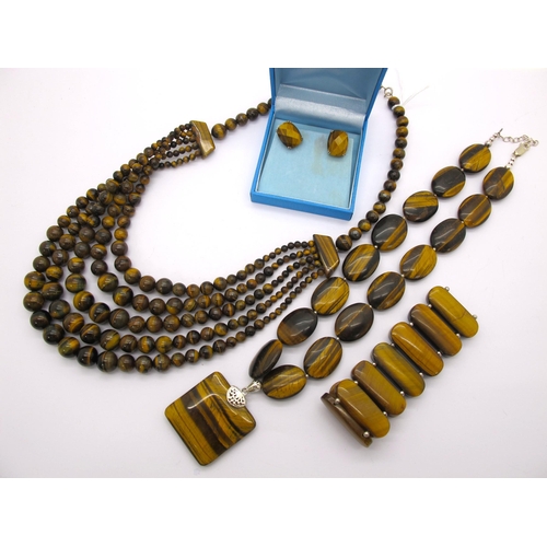 21 - A Modern Tiger's Eye Polished Flat Bead Necklace, together with a multi strand graduated bead neckla... 