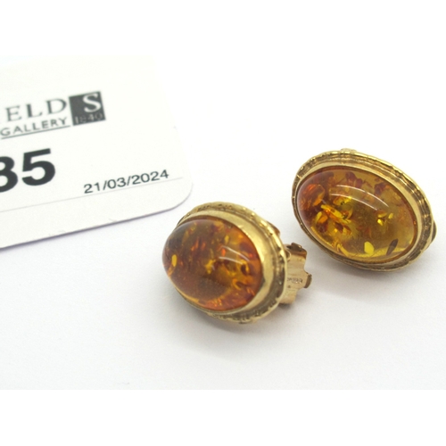 85 - A Pair of Modern 9ct Gold Amber Clip On Earrings, oval collet set.
