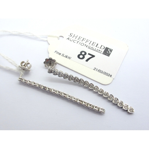 87 - A Pair of Modern 18ct White Gold Diamond Set Line Drop Earrings, of heart design, set throughout wit... 