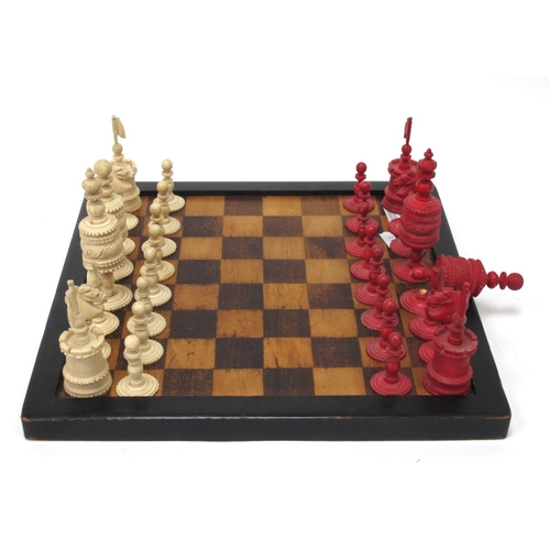 1282 - An Early XX Century Carved Bone Chess Set, with red stained and plain pieces, in box with board.