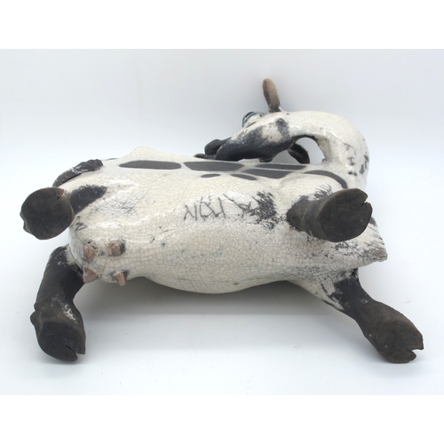 1063 - Lawson J. Rudge (b.1936) *ARR; A Raku Pottery Licking Flat Cow, spot pattern, numbered 5, unmarked, ... 