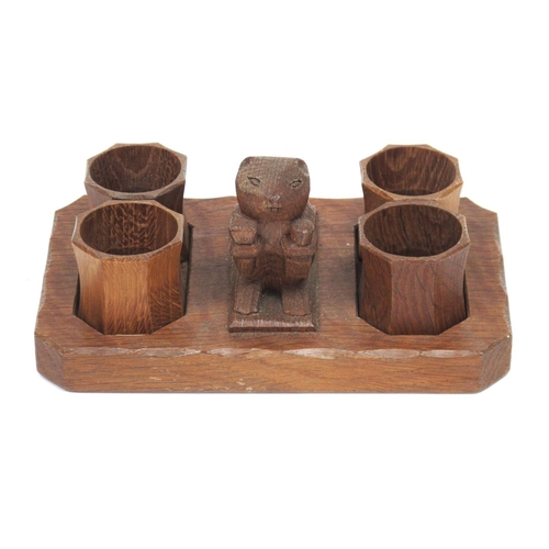 1302 - A Colin Almack 'Beaverman' Oak Napkin Set, carved with a central beaver and four napkin rings on a s... 