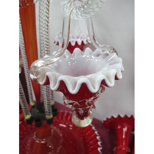 1033 - A Late XIX Century Red and White Glass Epergne, the shaped circular base with central trumpet vase s... 