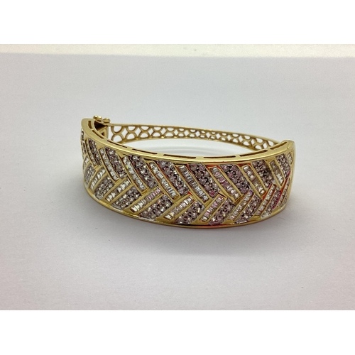 197 - A Modern Wide Front Hinged Bangle, channel and millegrain set throughout to the front (one stone mis... 