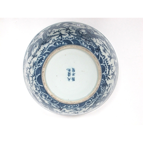 1121 - A Late XIX Century Large Chinese Pottery Circular Bowl, painted in blue with a central dragon chasin... 