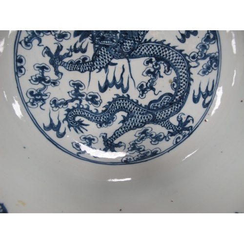 1121 - A Late XIX Century Large Chinese Pottery Circular Bowl, painted in blue with a central dragon chasin... 