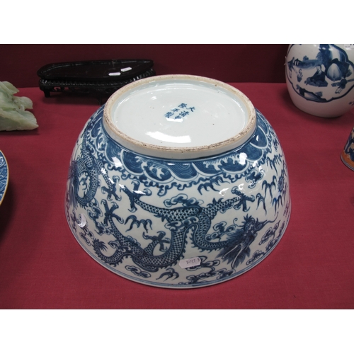 1121 - A Late XIX Century Large Chinese Pottery Circular Bowl, painted in blue with a central dragon chasin... 