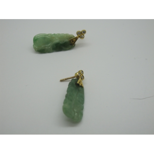 76 - A Pair of Carved Jade Drop Earrings, each with rubover set surmount; together with an oval panel pen... 