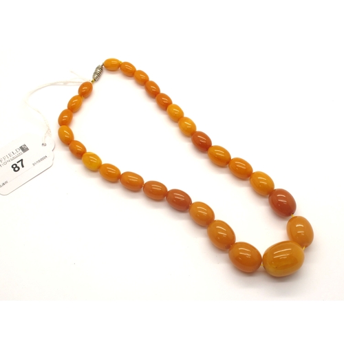 87 - A Graduated Single Strand Amber Colour Bead Necklace, approximately 42.5cm long.