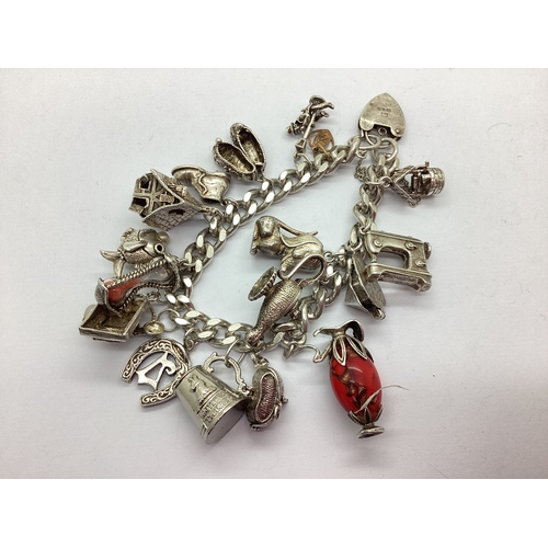 124 - A Vintage Chunky Curb Link Charm Bracelet, suspending assorted novelty charms, including articulated... 