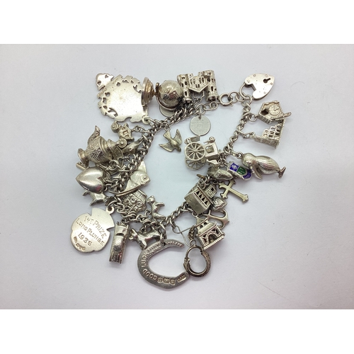 127 - A Chunky Curb Link Charm Bracelet, suspending assorted novelty charms, including a hallmarked silver... 