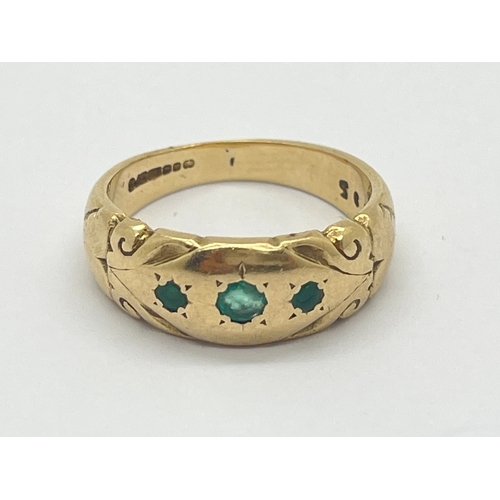 86 - A 9ct Gold Vintage Three Stone Emerald Ring, graduated rubover set of clover shape, between decorati... 