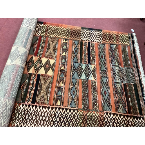 1533 - Shalamar Creations Tassled Wool Rug, with geometric strips on rust ground 188 x 139cm