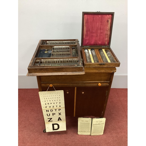 1272 - A 1930's Oak Cased Wheeled Cabinet of Optician's Lenses, with lift-up top, sliding shelf and two doo... 