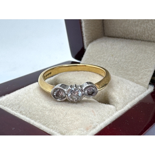 128 - An 18ct Gold Three Stone Diamond Ring, the circular brilliant cut centre stone, tension set between ... 