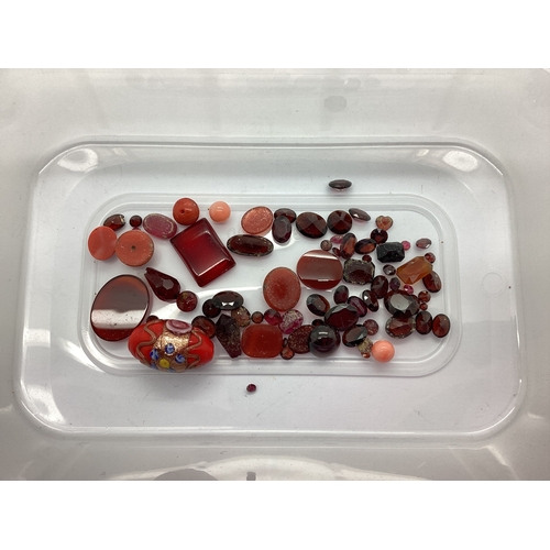 104 - A Collection of Loose Gems and Stones, in hues of red, to include oval cabochon, circular cut, recta... 