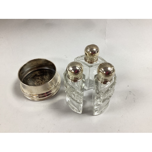 5 - A Set of Three Hallmarked Silver Mounted Scent Bottles, Chester 1923, the shaped bottled with partia... 