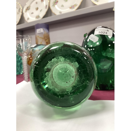 1211 - A Late XIX Century Green Glass Dump Paperweight, with flowerhead inclusions, 12cm high. Some surface... 