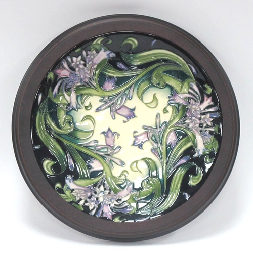 1210 - A Moorcroft Pottery Circular Plaque, decorated with a design of agapanthus by Emma Bossons, impresse... 