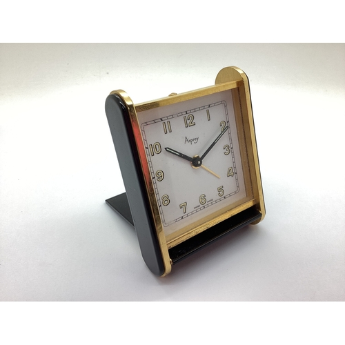 24 - Asprey; An Art Deco Style Travel Alarm Clock, in black and brass, case back stamped 