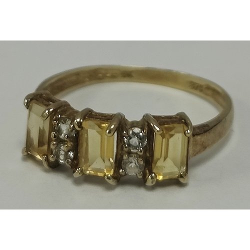 38 - A Stone Set Dress Ring, the three emerald cut stones alternately four claw set to round cut highligh... 