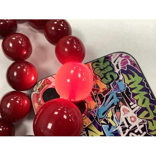 129 - A Cherry Coloured Beaded Necklace, the spherical beads of graduated size, to invisible barrel clasp,... 