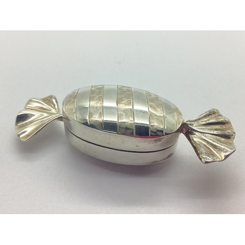 125 - A Modern Novelty Hallmarked Silver Pill Box, as a wrapped sweet, 6.3cm long.