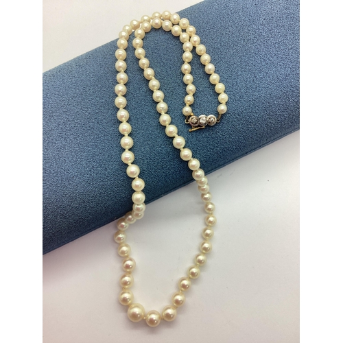 184 - A Three Stone Diamond Inset Clasped Single Strand Freshwater Pearl Bead Necklace, the pearl beads of... 