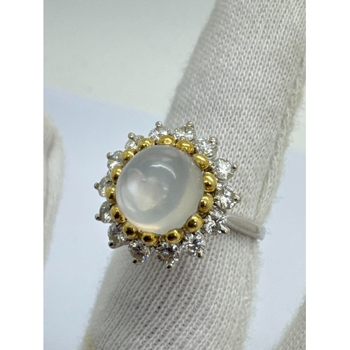 271 - A Modern Moonstone and Diamond Circular Cluster Ring, high cabochon set to the centre, gold bead cla... 