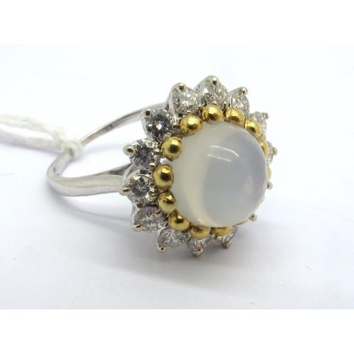 271 - A Modern Moonstone and Diamond Circular Cluster Ring, high cabochon set to the centre, gold bead cla... 