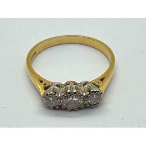 273 - An 18ct Gold Three Stone Diamond Ring, the brilliant cut diamonds graduated claw set between tapered... 