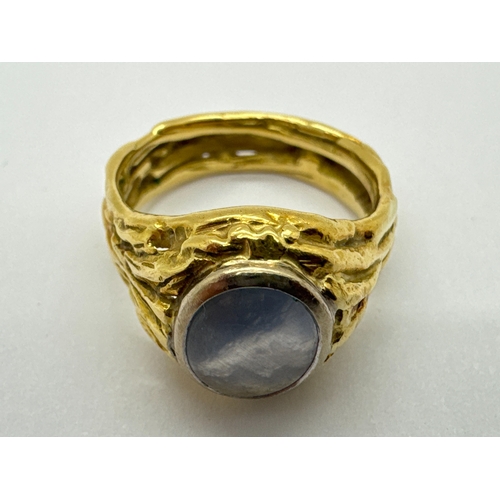 274 - An 18ct Gold Modernist Style Single Stone Set Ring, the oval cabochon rubover set within bark textur... 