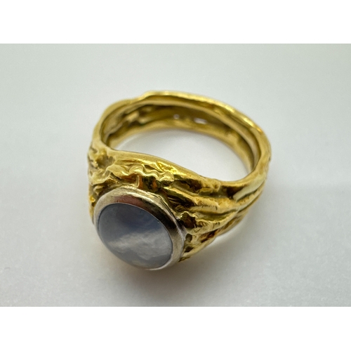 274 - An 18ct Gold Modernist Style Single Stone Set Ring, the oval cabochon rubover set within bark textur... 