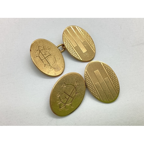 360 - A Pair of 9ct Gold Cufflinks, the oval panels part engine turned and monogrammed, on chain connectio... 