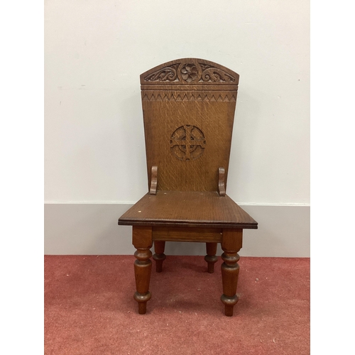 1547 - An Ecclesiastical Oak Chair, the top with carved scroll and cross decoration, on turned legs.