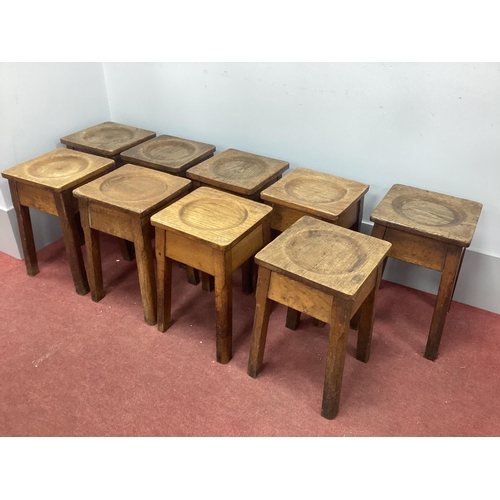 1555 - A Set of Nine Oak Stools, with square tops, dished seats on square supports.