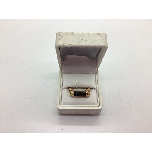 54 - Korite; An Ornate Ammolite Set Ring, the elongated panel semi set between greek key style bifurcated... 