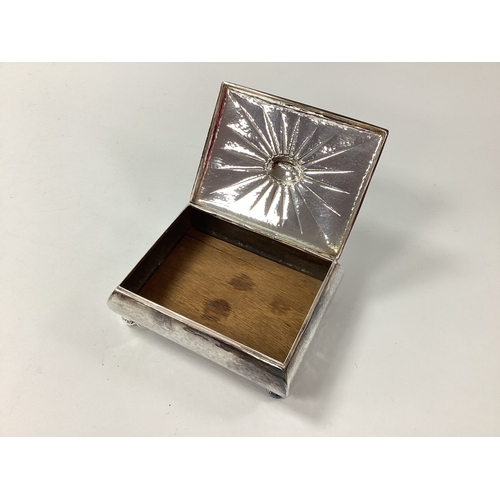 7 - A Rectangular Trinket Box, the hinged lid with textured design, raised on four bun feet, stamped 