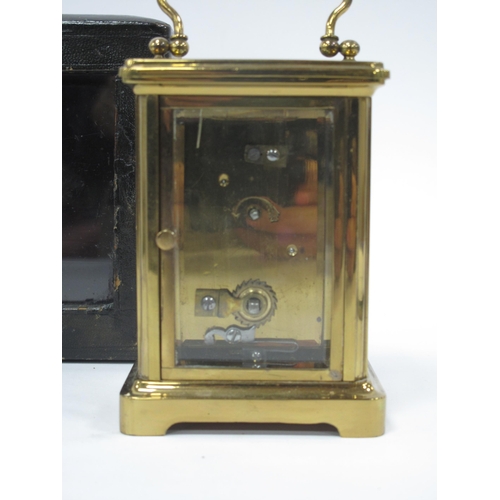 1340 - A XX Century Brass Carriage Clock, the white enamel dial with black Roman numerals,15cm high (handle... 