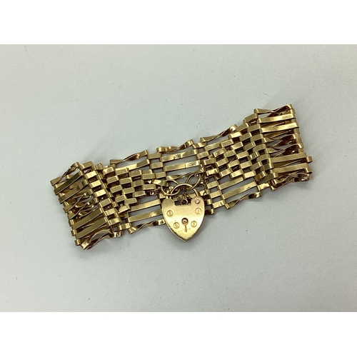 129 - A Wide 9ct Gold Gate Link Bracelet, to heart shape padlock clasp and safety chain, overall length ap... 