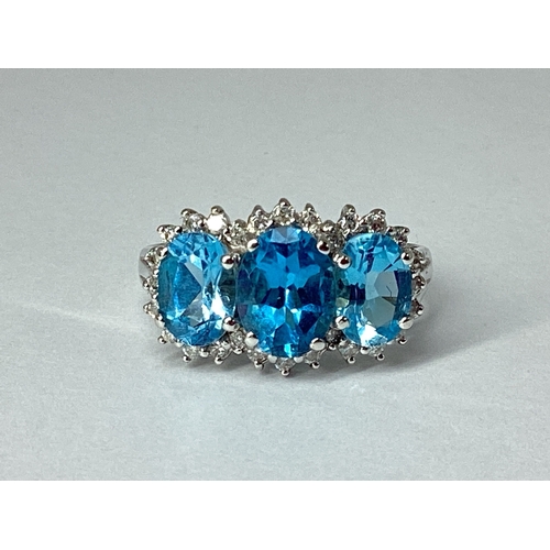 71 - A Blue Topaz and Diamond Triple Cluster Ring, claw set throughout, between reeded shoulders, indisti... 